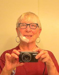 A selfie showing my bandaged face after a basal cell carcinoma was removed. I drank my coffee this morning through a straw. The big bandage, thankfully, comes off tomorrow and then there is just the tape over the stitches.-- Selfie by Pat Bean